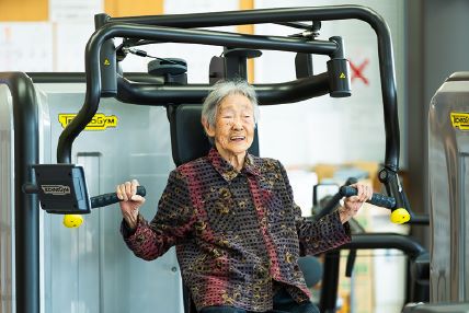 トレーニング機器を使用する女性の老人
